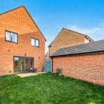 Brick house with garden and patio furniture.