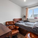 Cosy room with desk, bed, and window view.