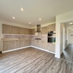 Modern kitchen with wooden cabinets and hallway view.