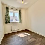 Bright room with wooden floor and green curtains.
