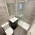 Modern bathroom with shower, sink, and toilet.