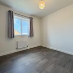 Empty room with window and wooden floor.