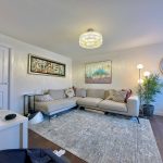 Modern living room with beige sofa and art decor.