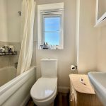 Modern bathroom with bathtub and window.