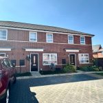 Red brick terraced houses with parked car.