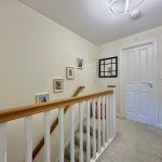 Staircase with framed pictures on wall.