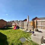 Backyard with shed, slide, and seating area.