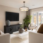 Modern living room with plants and large TV.