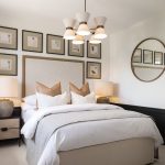 Stylish bedroom with framed artwork and round mirror.