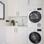 Modern utility room with stacked washer, dryer.