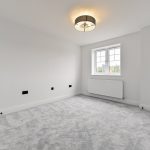 Empty room with grey carpet and window.