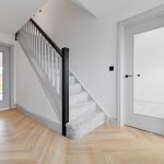 Modern hallway with staircase and wooden floor