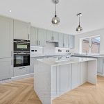 Modern kitchen with light cabinets and island.