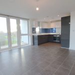 Modern open-plan kitchen with large windows and tiled floor.