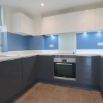 Modern kitchen with blue and white cupboards.