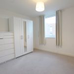 Bright minimalistic bedroom with wardrobe and chest of drawers.