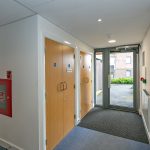 Hallway with doors and fire safety equipment.