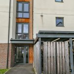 Modern apartment building entrance with wooden bike storage