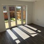 Bright empty room with garden view through doors.