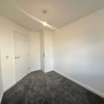 Empty room with grey carpet and white walls.