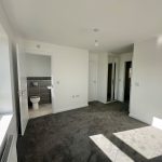 Bright empty room with carpet and en-suite bathroom.
