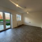 Empty room with garden view and tiled floor.