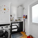 Modern utility room with washing machine and sink.