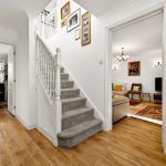 Bright hallway with stairs, kitchen, and living room.