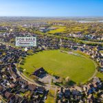 Aerial view of housing estate with for sale sign.
