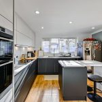 Modern kitchen with island and bar stools.