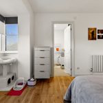 Bedroom with cat tree and bathroom view.