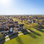 Aerial view of suburban houses and green area.