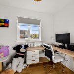 Cosy home office with desk and stuffed animals.