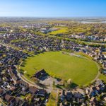 Aerial view of housing estate with large green field.