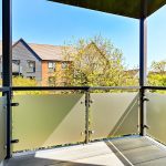 Modern balcony overlooking garden and residential homes