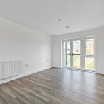Spacious empty room with large windows and wooden floor.