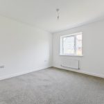 Empty room with grey carpet and window.