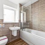 Modern bathroom with bathtub and beige tiles