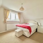 Cosy bedroom with double bed and window view.