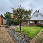 Small landscaped garden with modern house.