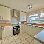 Modern kitchen with white cabinets and wooden countertops.