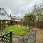 Backyard with lawn, trees, and gravel pathway