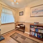 Cosy room with bookcase and beige curtains.