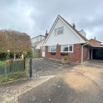 Modern detached house with driveway and garden.