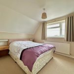 Cosy bedroom with double bed and window view.