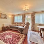 Comfortable living room with sofa, rug, and dining table.