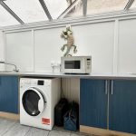Utility room with washing machine and microwave.