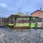 Patio garden with trellis and brick house