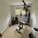 Home gym with weightlifting equipment.