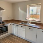 Modern kitchen with wooden countertops and gas hob.